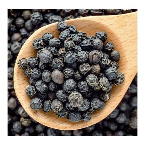 Black peppercorns in a wooden spoon