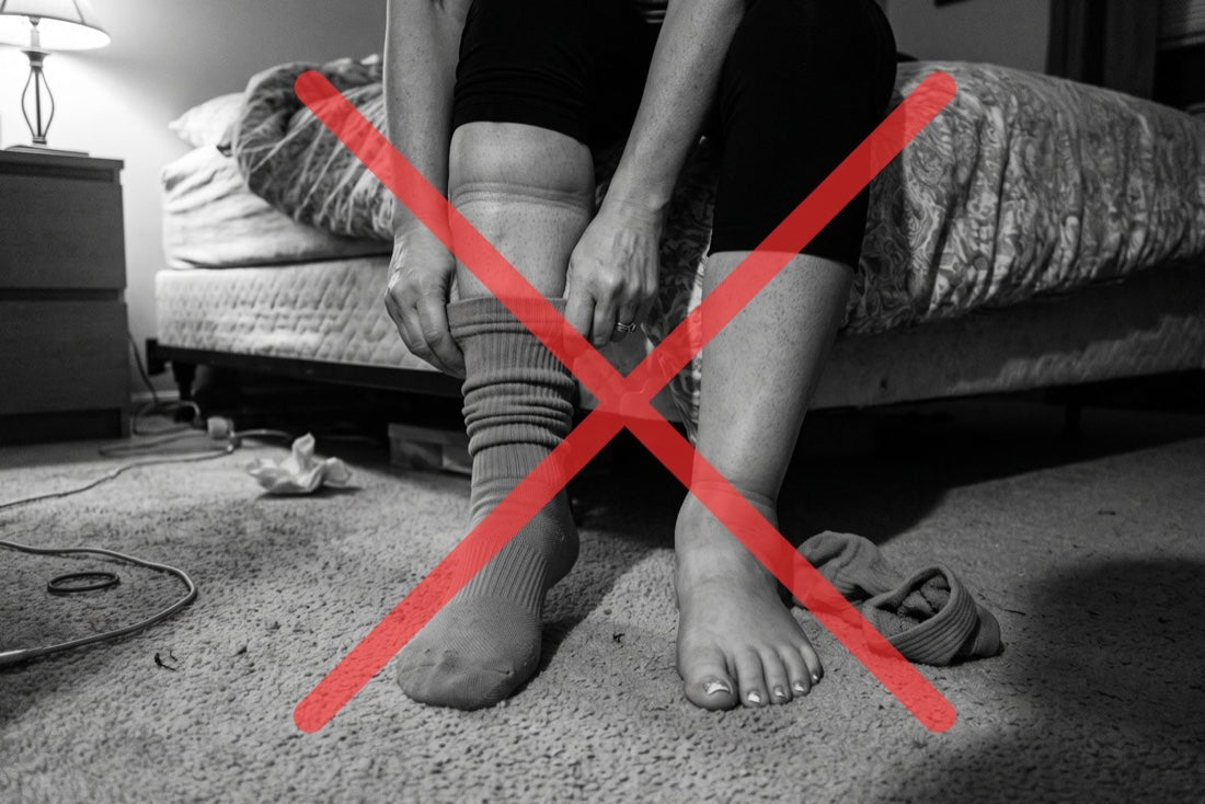 Woman pulling on compression socks, crossed out in red — compression only moves fluid temporarily
